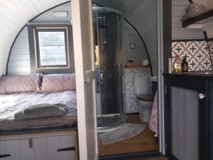 a bathroom with a shower and a bed in a room at Etive Pod, West Highland Way Holidays in Kinlochleven