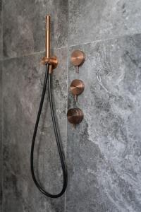 a shower with a hose on a wall at Tra monte e lago in Terlago