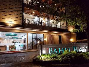 a building with a sign in front of it at night at BahuBay Hotel Manado in Malalayang