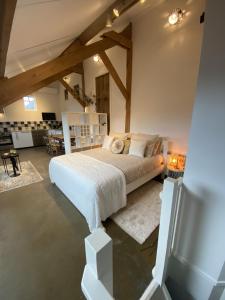 Un dormitorio con una cama grande en una habitación con techos de madera. en B&B / Studio De Rozeboom, en Steenbergen