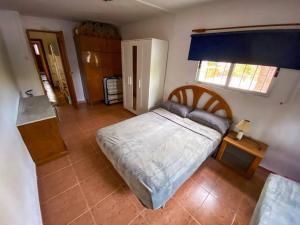 1 dormitorio con cama, mesa y ventana en Villa Caliqueña, casa de campo, en Torrent