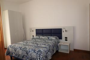 een slaapkamer met een bed met een blauwe en witte sprei bij Francesco Suite in Sorrento