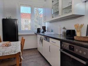 a kitchen with white cabinets and a table and a tableablish at BurgK59, 3 BR, 6 Beds, TV, Kitchen and Bath in Muldenstein