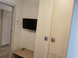 a room with a closet with a tv and a cabinet at Cabà Holiday Bardolino Santa Cristina in Bardolino