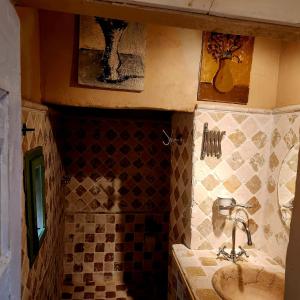 uma casa de banho com um lavatório e uma parede em azulejo em La casa degli artisti em Marliana