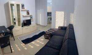 a living room with a couch and a television at Diamond Hill Apartment in Vlorë