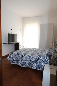 een slaapkamer met een blauw en wit bed en een raam bij Francesco Suite in Sorrento