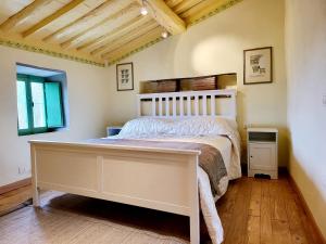 1 dormitorio con cama blanca y ventana en La casa degli artisti en Marliana
