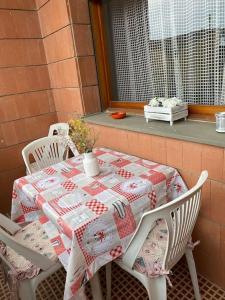 uma mesa e cadeiras com uma colcha num alpendre em Casa Lucia a due passi dal mare Wi-Fi free parking em Principina a Mare