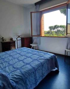 um quarto com uma cama azul e uma janela em Casa Lucia a due passi dal mare Wi-Fi free parking em Principina a Mare