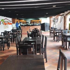 Hotel y Restaurante Casa Medina في La Plata: غرفة طعام مع طاولات وكراسي وتلفزيون