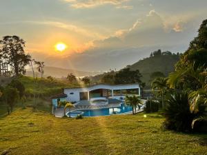 a house with a swimming pool at sunset at Finca Calimita in Calima