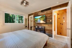 a bedroom with a bed and a tv on a wall at River Otter Hot Tub BBQ Fire Pit Russian River Gem in Rio Nido