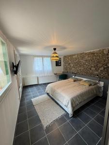 sypialnia z łóżkiem i kamienną ścianą w obiekcie Maison Cosy w mieście Rezé