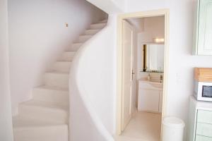 Una escalera blanca en un baño con lavabo en Villa Mando en Super Paradise Beach