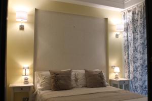 薩雷諾的住宿－SALERNO HOME STATION，一间卧室配有一张带2个床头柜和2盏灯的床。