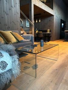 sala de estar con mesa de cristal y sofá en Pow Panorama - High standard Mountain home en Sogndal