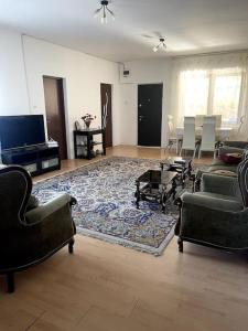 a living room with couches and a rug at Căsuța de la țară in Bradu