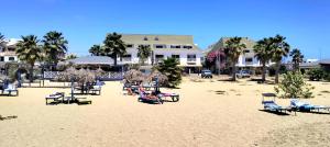 a group of beach chairs and umbrellas on a beach at Residencial Ilha do Maio App 101 in Santa Maria