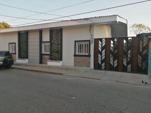 een huis met een hek en een auto die ervoor geparkeerd staat bij LA ESTANCIA in Comayagua