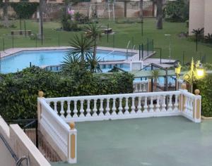 - un balcon avec une balustrade blanche et 2 piscines dans l'établissement Calle La Playa, à Torremolinos