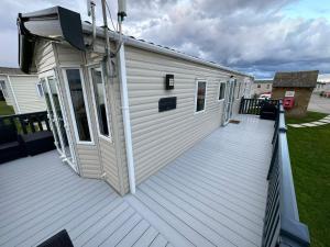 a house with a large deck with a building at Sunset Paradise in Selsey