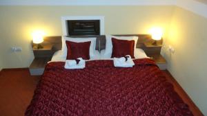 a bedroom with a large red bed with red pillows at Villa Bastion in Bitola +6 photos