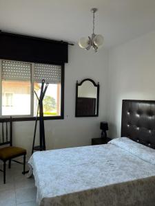 um quarto com uma cama, uma cadeira e um espelho em Marea Alta de Playa América em Nigrán