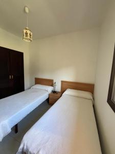 duas camas num quarto com lençóis brancos em Marea Alta de Playa América em Nigrán