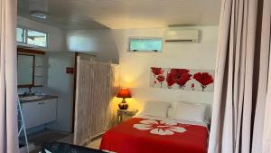 a bedroom with a bed with a red blanket at DAMYR PLACE in Faaa