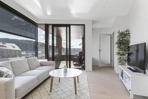 a living room with a white couch and a table at New waterfront apartment - Oslo city centre in Oslo