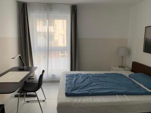 1 dormitorio con cama, escritorio y ventana en Fair Apartment, en Hannover