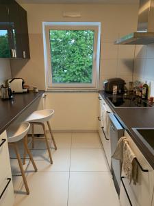 una cocina con una ventana y dos taburetes. en Fair Apartment, en Hannover