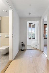 a white bathroom with a toilet and a tub at New waterfront apartment - Oslo city centre in Oslo