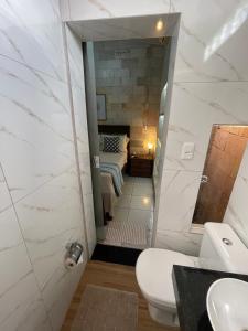 een badkamer met een spiegel en een bed in een kamer bij Casa de Pedra in Pirenópolis