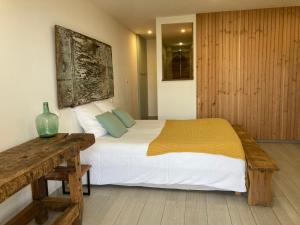 a bedroom with a large bed and a wooden table at Casa Santa Giulia in Propriano