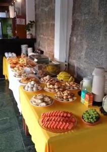 una mesa larga con muchos platos de comida. en Hotel Beira Rio Guararema en Guararema