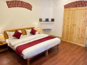 sypialnia z dużym łóżkiem z czerwonymi poduszkami w obiekcie The Nishantam Boho Heritage near mall w mieście Mussoorie