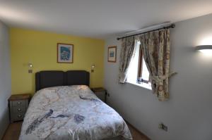 1 dormitorio con cama y ventana en The Wallow, en Penzance