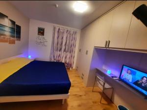 een slaapkamer met een bed en een bureau met een televisie bij New Bedrooms Mamma Gigetta in Noventa di Piave