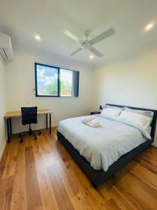 a bedroom with a bed and a desk and a window at Modern Private Room 1,2 close to QEII & Grifith Uni in Brisbane