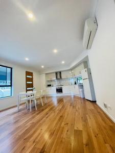 an empty living room with a table and a kitchen at Modern Private Room 1,2 close to QEII & Grifith Uni in Brisbane