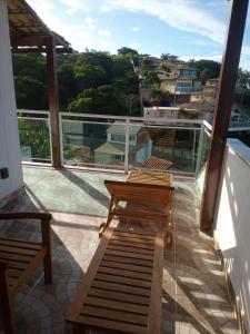 dos bancos sentados en el balcón de una casa en Casa Temporada Sol E Lua, en Búzios