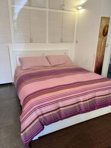 Una cama con una manta de colores en una habitación en [FREE PARKING]Appartamento angolo di relax!!!, en Rivoli