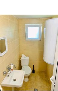 a bathroom with a white toilet and a sink at Krimski Guest House and Bungalows in Byala