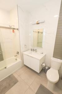 a bathroom with a toilet and a shower and a sink at Spacious 3-BR Luxury Suite near New York City in Union City