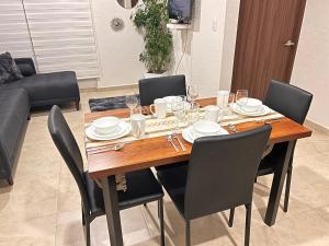 a dining room table with chairs and plates and glasses at Bonito departamento en CDMX in Mexico City