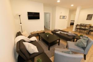 een woonkamer met banken en stoelen en een televisie bij Spacious 3-BR Luxury Suite near New York City in Union City