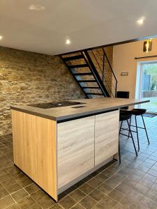 a kitchen with a island in a room with a stone wall at La Maisonnette in Theux