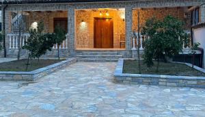 a house with two trees in front of a door at Eni entire guesthouse parking on site in Berat